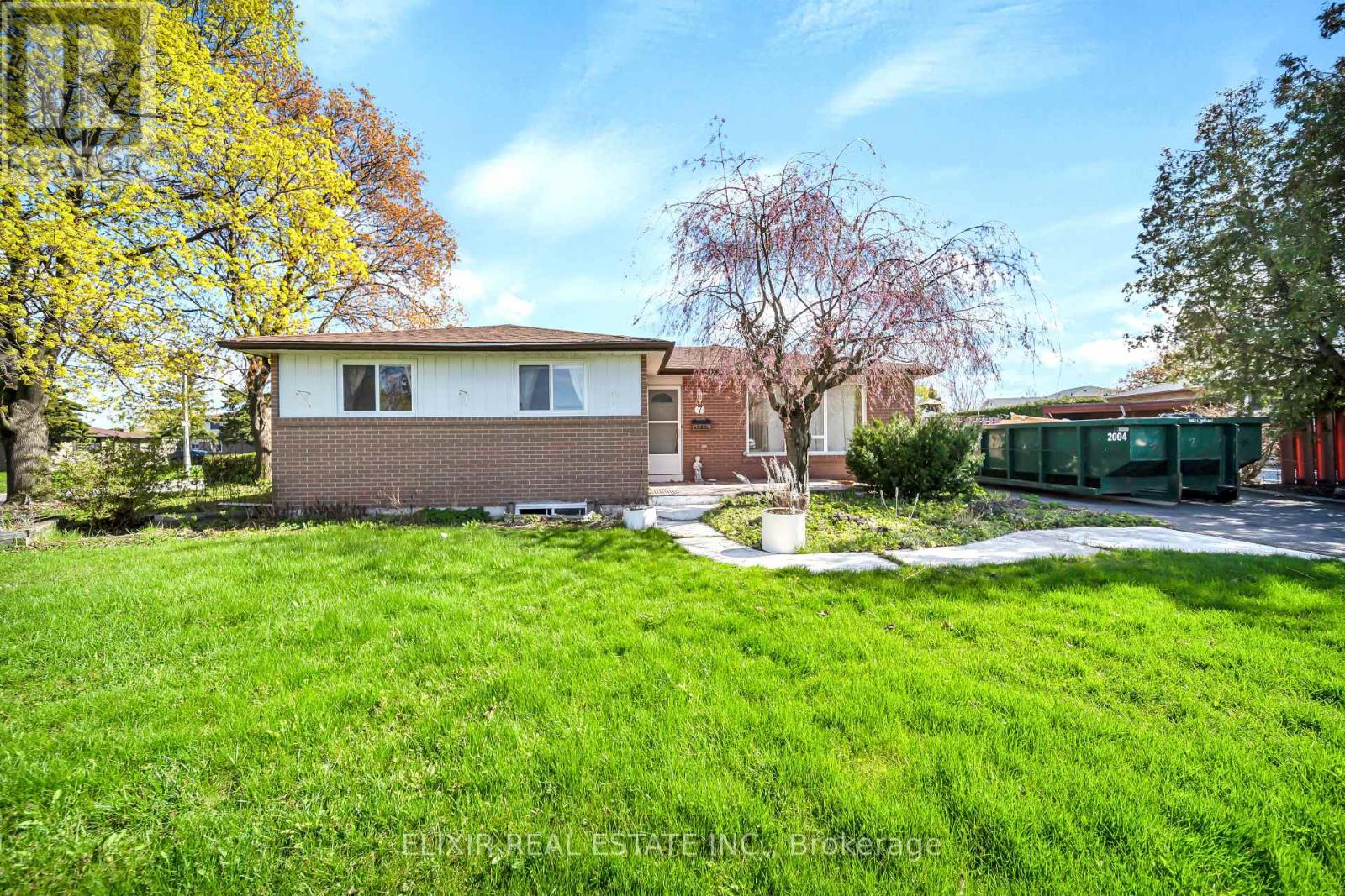 A house with a green lawn and trees in the background.