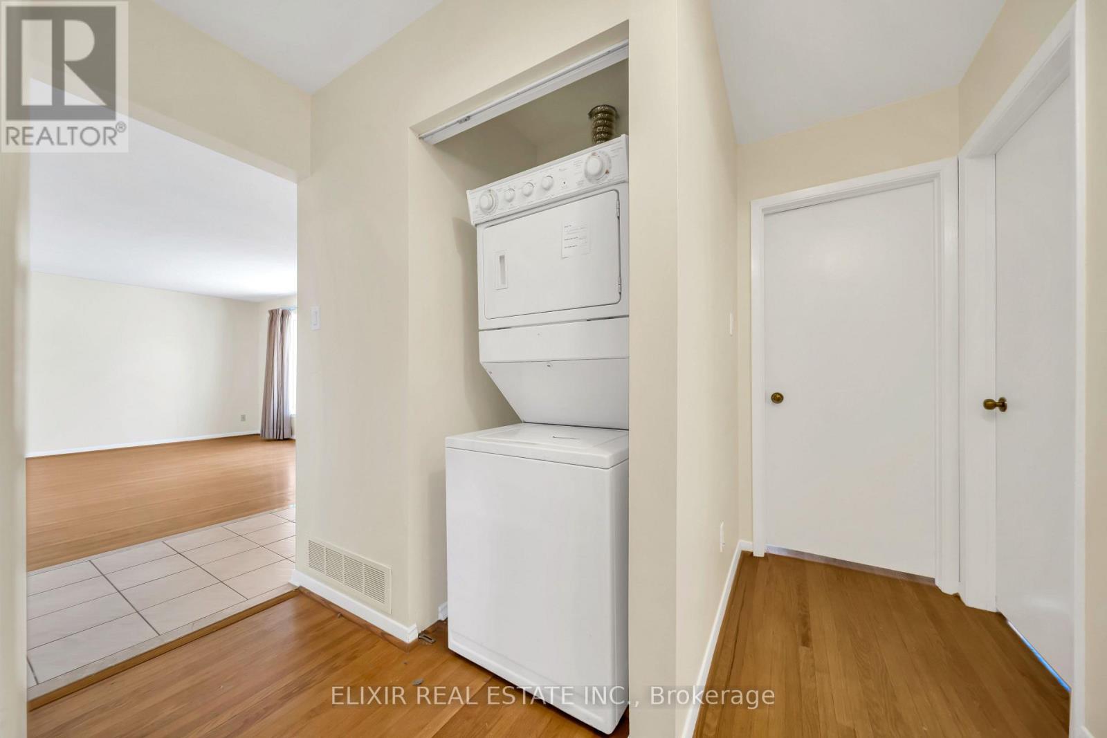 A white oven and dishwasher in a kitchen with wooden floors.