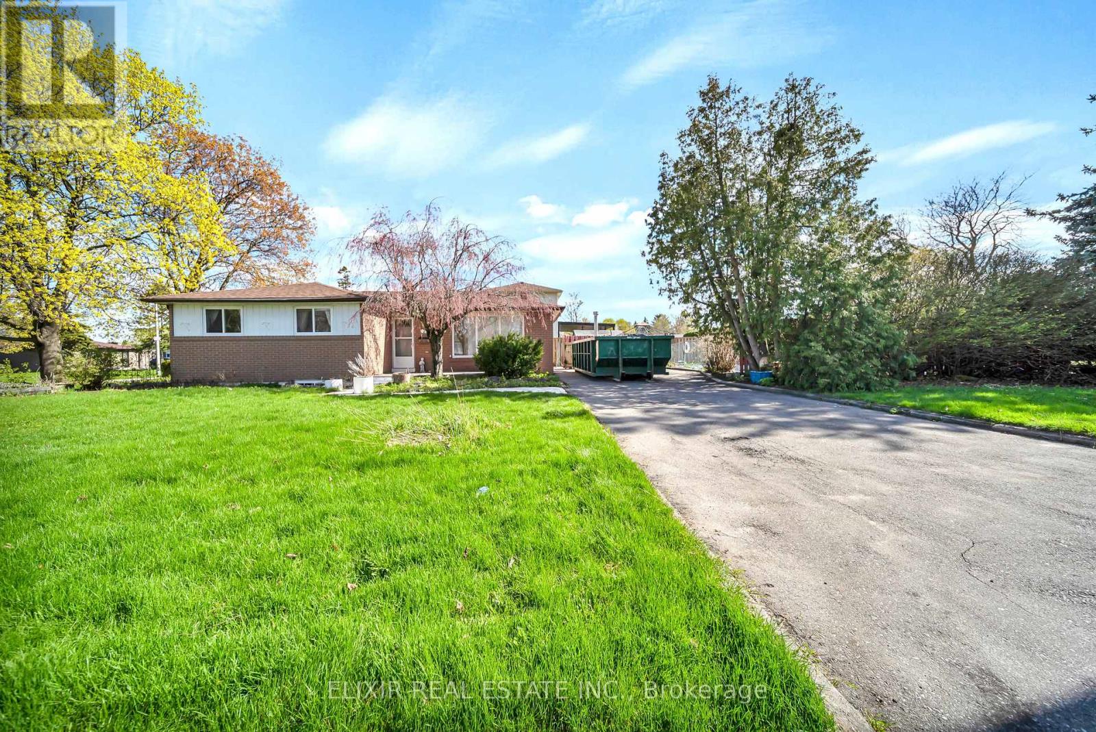 A residential area with a house, trees, and a driveway.