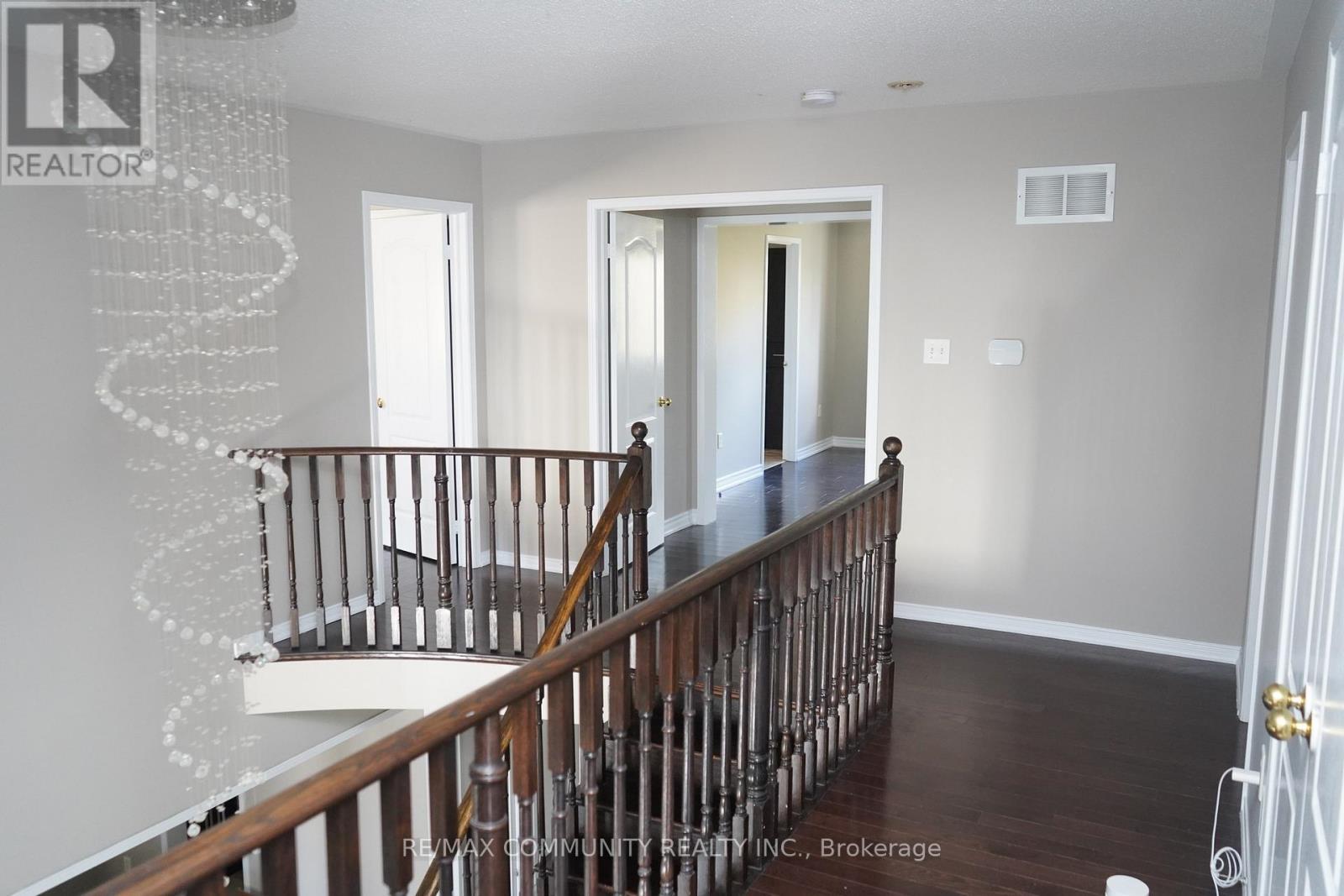 A spacious room with a staircase leading to the second floor.