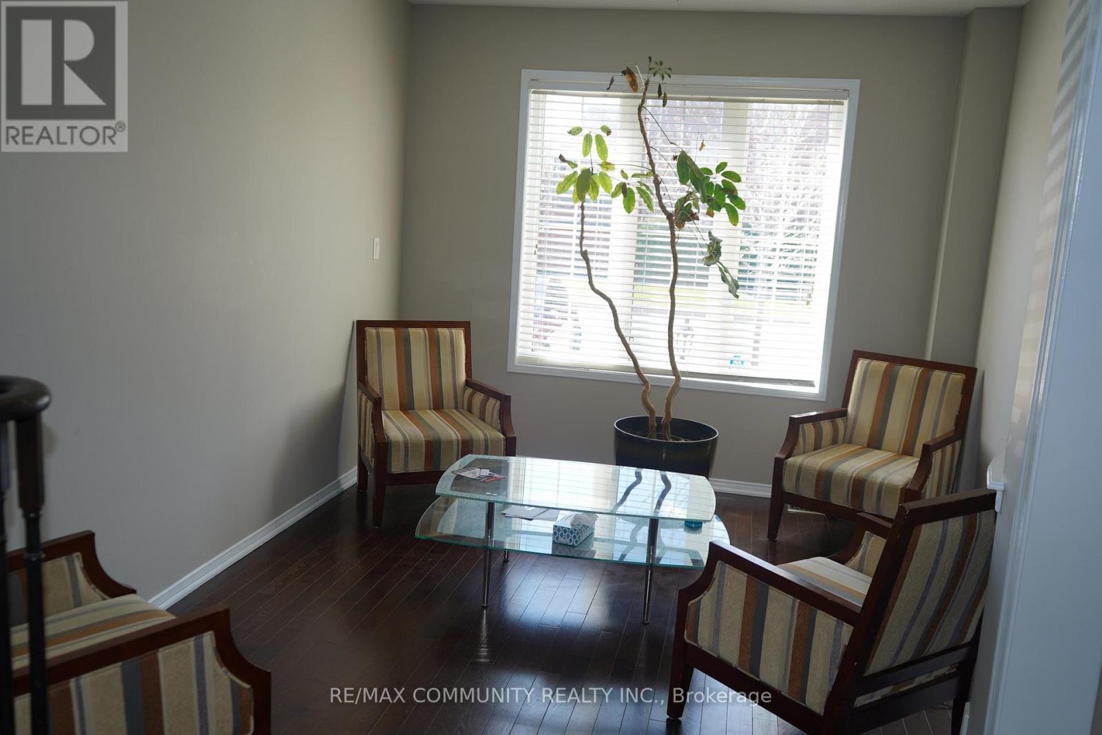 A living room with a glass table and striped chairs.