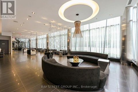 A modern living room with a large circular table and a chandelier hanging from the ceiling.