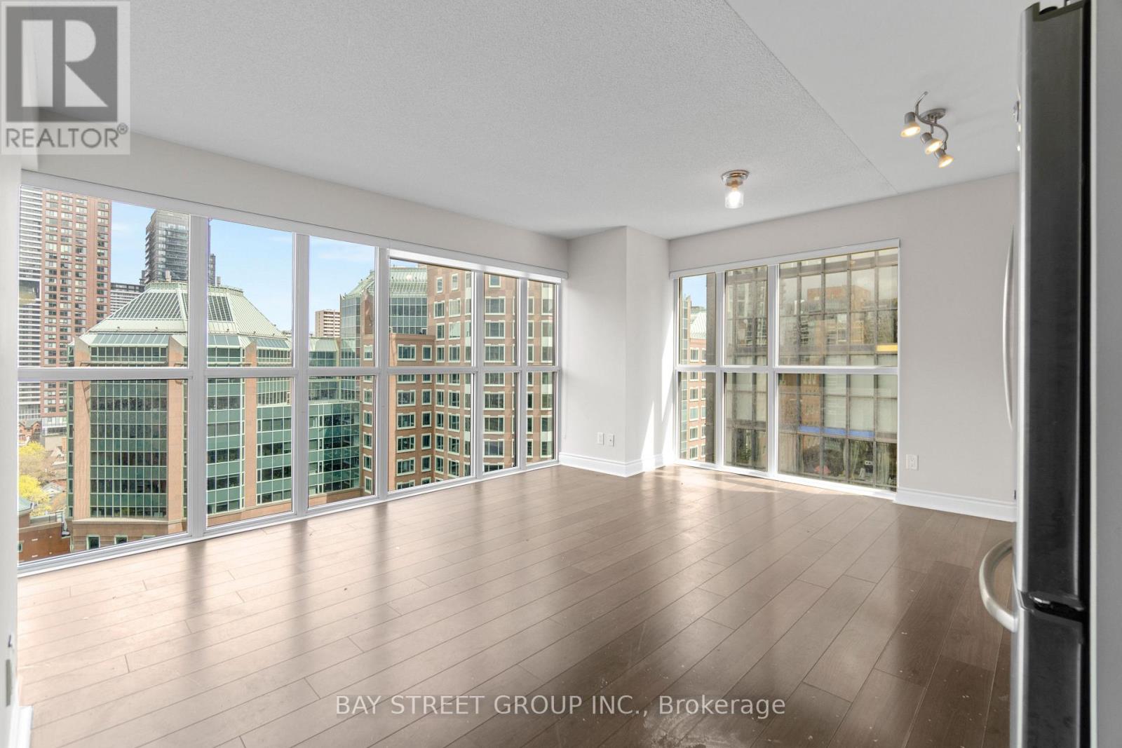 A spacious room with a view of the cityscape through large windows.