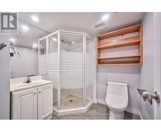 A white bathroom with a walk in shower and a toilet.