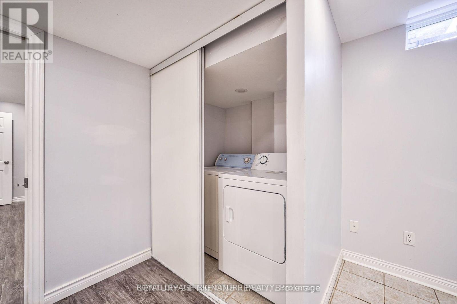 A white washing machine is in a small laundry room.