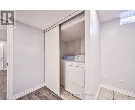 A white washing machine is in a small laundry room.