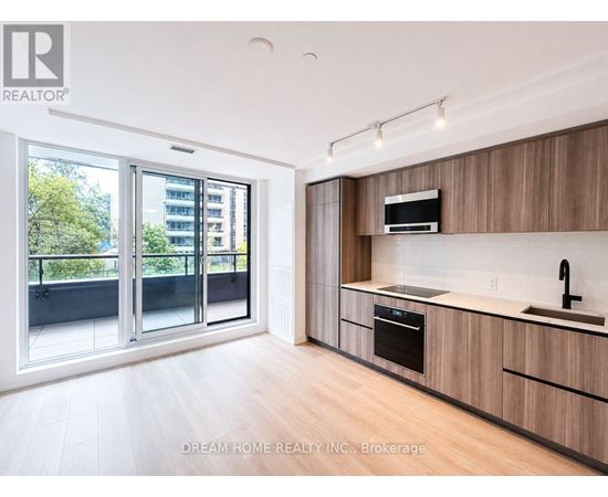 A modern kitchen with wooden cabinets and a stainless steel oven.