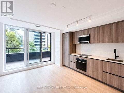 A modern kitchen with wooden cabinets and a stainless steel oven.