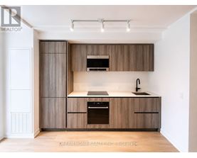 A modern kitchen with wooden cabinets and a stainless steel oven.