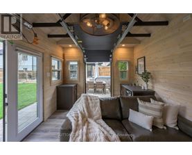 A modern living room with a grey couch and a wooden ceiling.