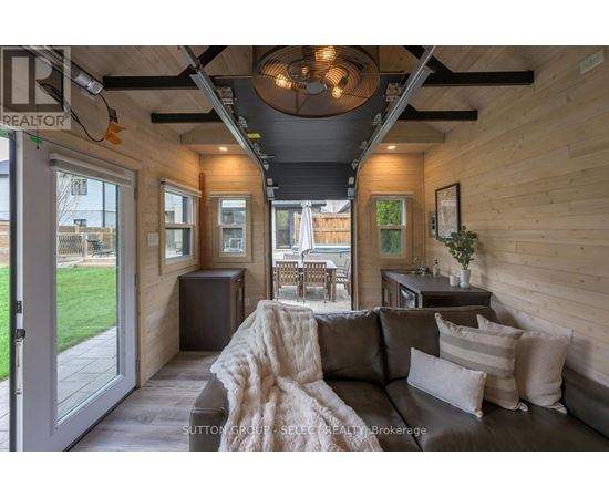 A modern living room with a grey couch and a wooden ceiling.
