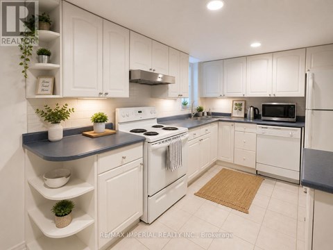 A kitchen with white cabinets and a black countertop.