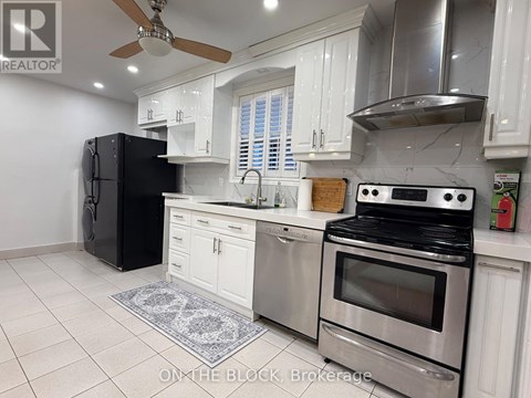 A modern kitchen with stainless steel appliances and white cabinets.