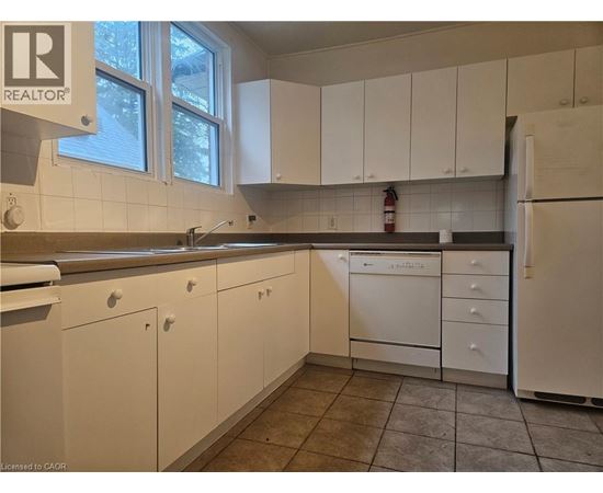 A kitchen with white cabinets and a dishwasher.