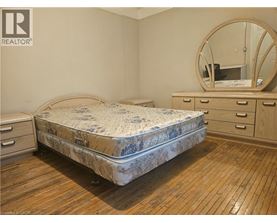 A bedroom with a round mirror and a bed with a floral patterned bedspread.