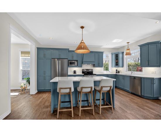 A kitchen with blue cabinets and a white island.