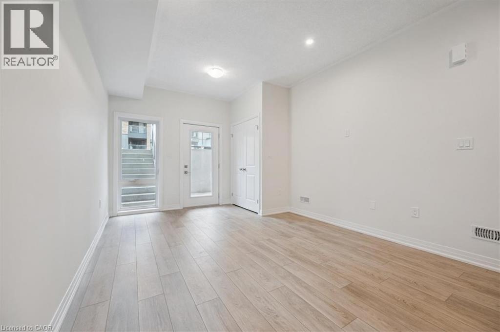 A spacious room with wooden flooring and white walls.