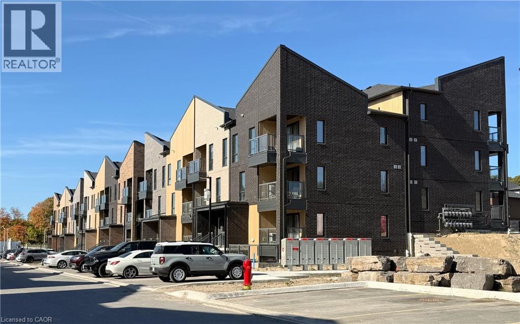 A row of modern apartment buildings with cars parked in front.