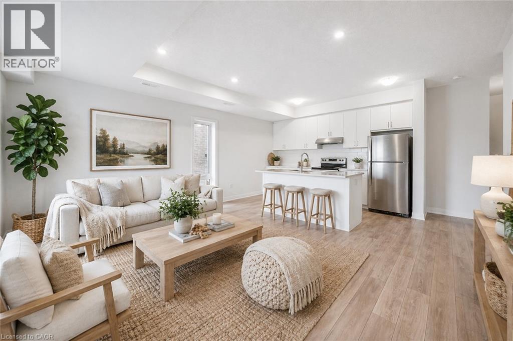 A well-lit, modern living room with a kitchen in the background.