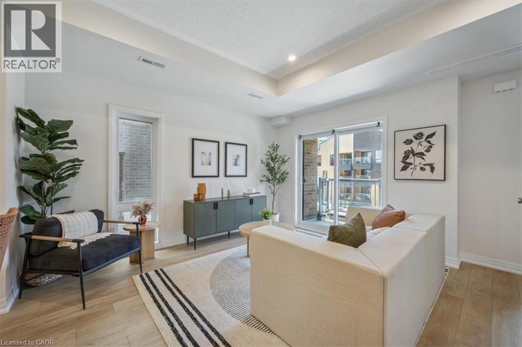 A living room with a sofa, a chair, a rug and pictures on the wall.