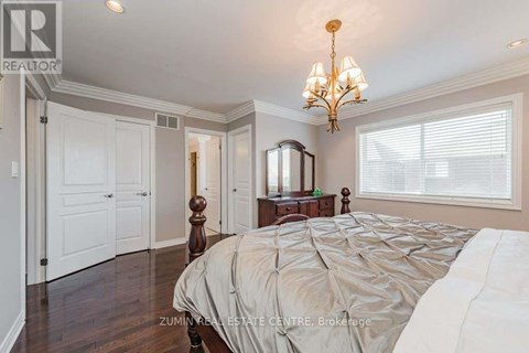 A bedroom with a large bed and a chandelier.