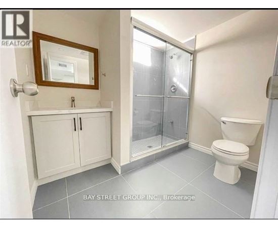 A white bathroom with a toilet, sink, and medicine cabinet.