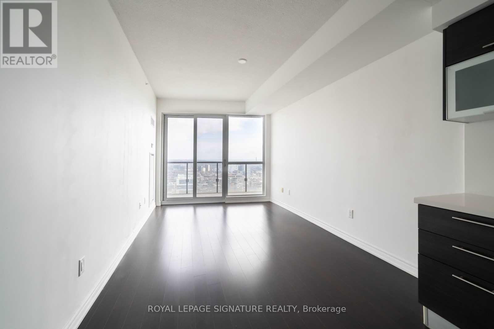 A spacious room with a large window overlooking a cityscape.