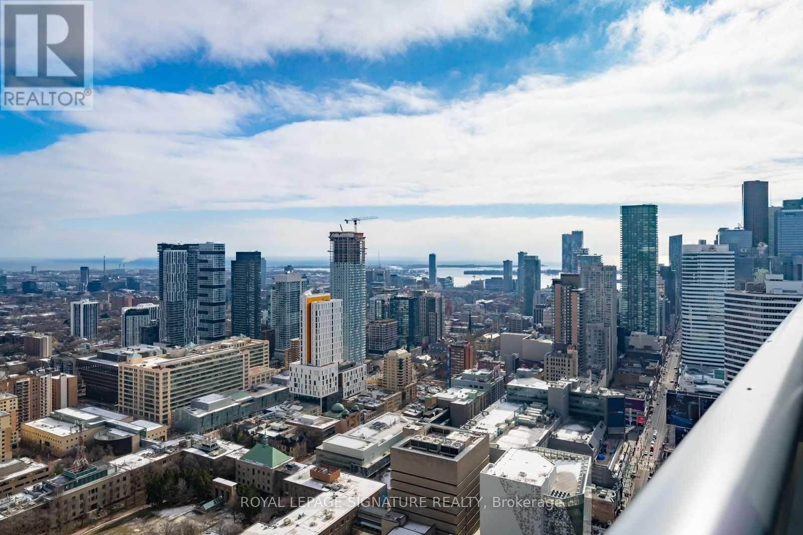 A cityscape with a mix of modern and older buildings, some with snow on the ground.