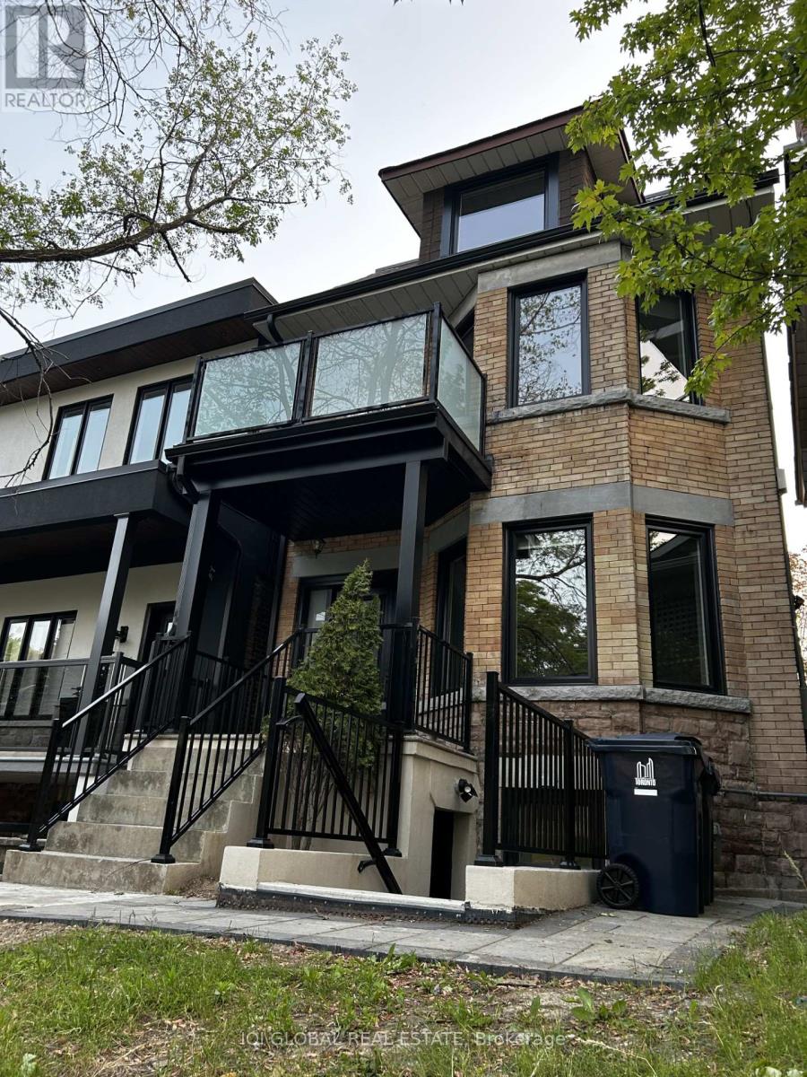 A modern house with a black metal railing on the stairs.