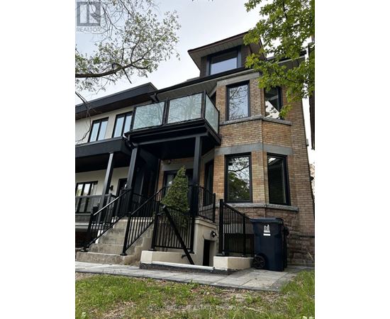 A modern house with a black metal railing on the stairs.
