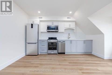 A kitchen with white cabinets and stainless steel appliances.