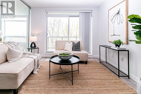 A living room with a couch, a coffee table, and a painting on the wall.