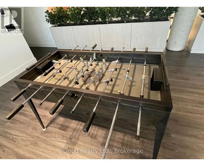 A pool table with a brown felt cloth and metal legs.
