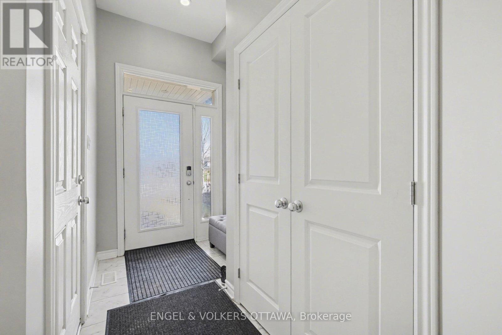 A hallway with white doors and a black and white striped rug.