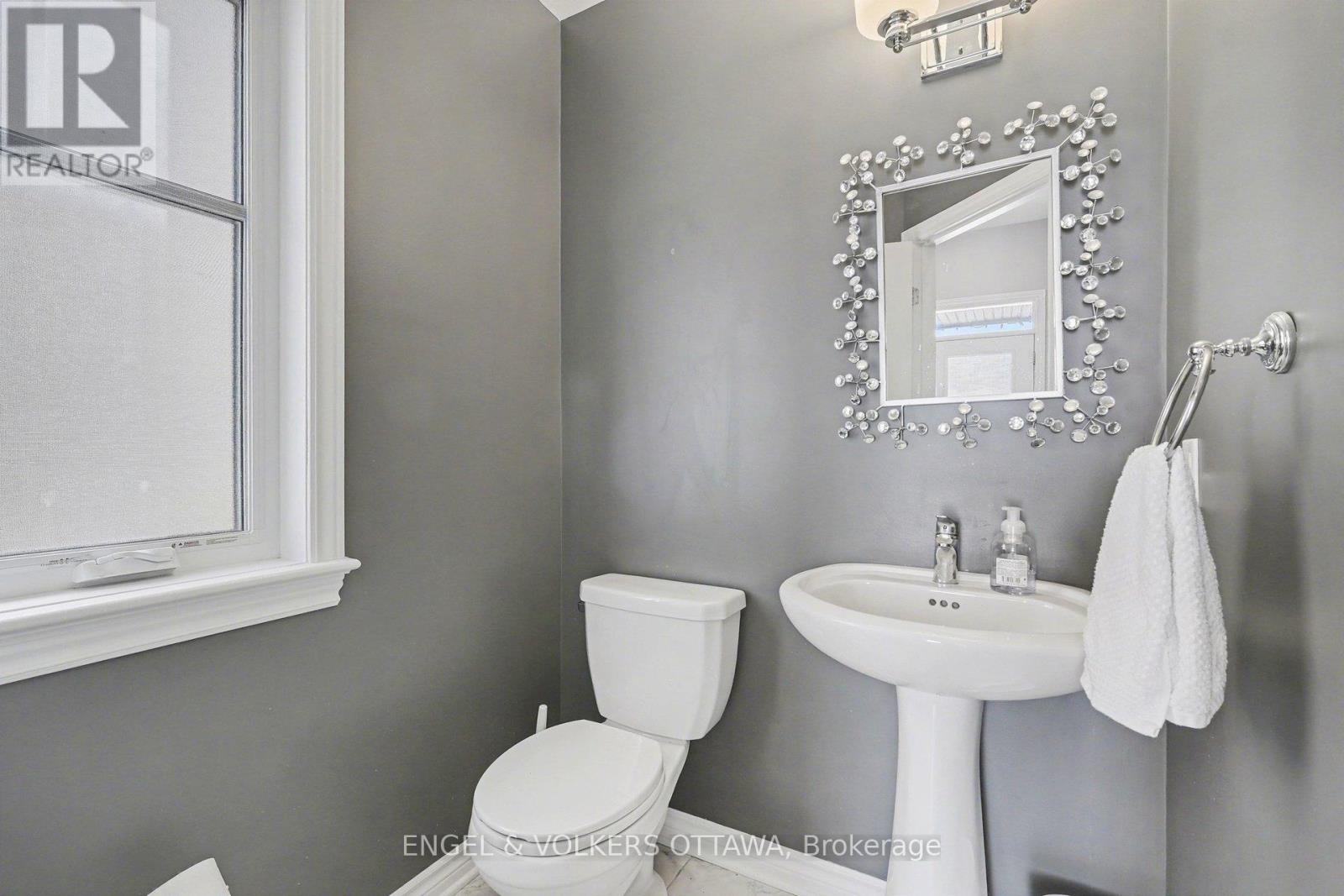 A white toilet and sink in a bathroom.