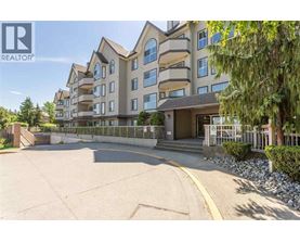 A large apartment complex with a parking lot in front.