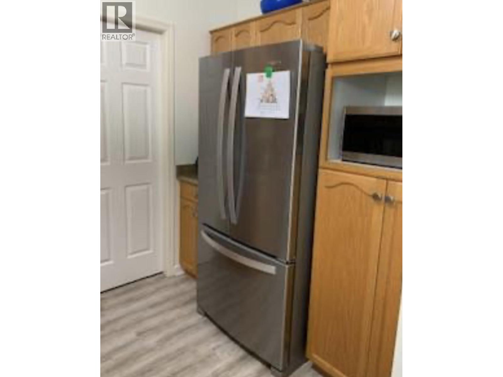 A refrigerator with a magnet on it in a kitchen.
