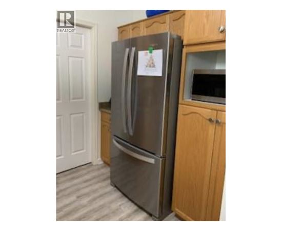 A refrigerator with a magnet on it in a kitchen.