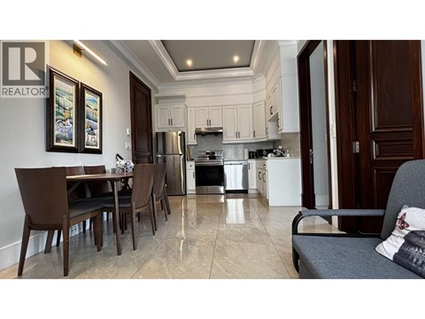 A kitchen with a dining table and chairs.