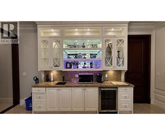 A kitchen with white cabinets and a granite countertop.