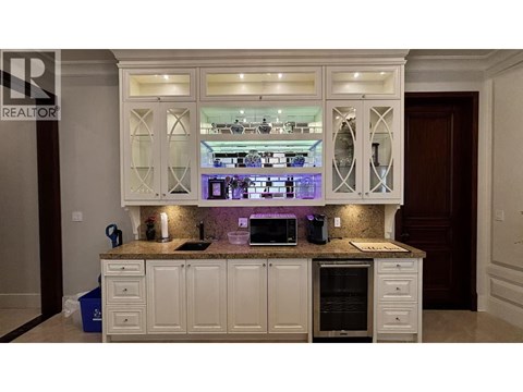 A kitchen with white cabinets and a granite countertop.