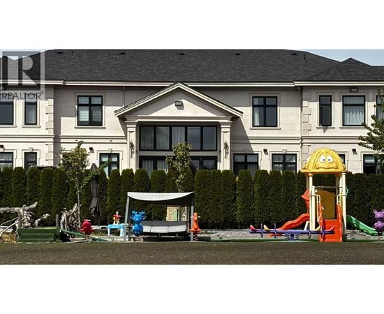 A playground with a slide and a slide in front of a large house.