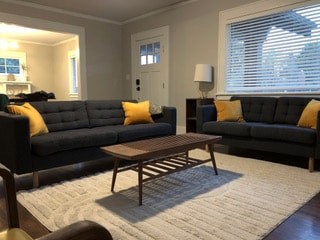A living room with two grey couches and a wooden coffee table.