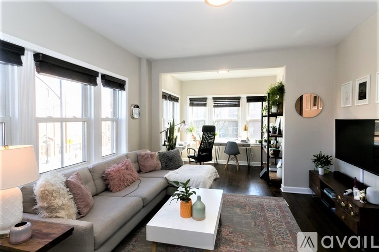 A living room with a grey couch and a coffee table in front of it.