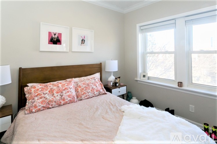 A bedroom with a large bed and two framed pictures on the wall.