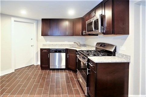 A kitchen with brown cabinets and a stainless steel dishwasher.