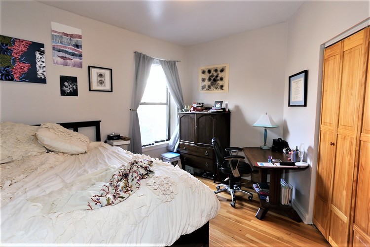 A bedroom with a large bed and a wooden door.