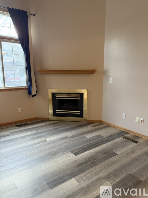 A room with a fireplace and wooden flooring.
