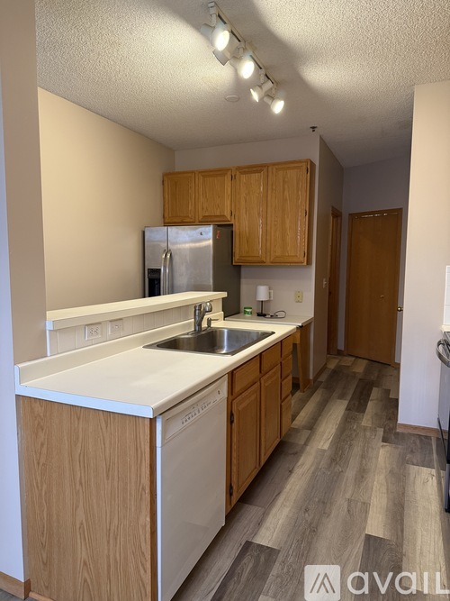 A kitchen with wooden cabinets and a white countertop.