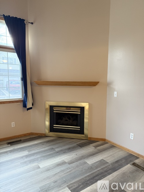 A modern living room with a fireplace and grey wood flooring.